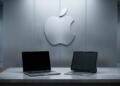 Logo de Apple junto a una MacBook y un iPad en una escena sobria.