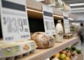 Etiquetas de precios dominan productos básicos en un supermercado.