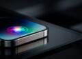 Primer plano de un smartphone de metal con el icono multicolor de Siri en su pantalla.