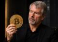 Michael Saylor sostiene una gran moneda de Bitcoin en un entorno corporativo.