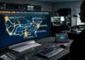 Persona mira monitor con mapa de EEUU que muestra red eléctrica y nodos de Amazon web service activos