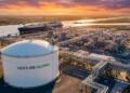 Planta de GNL de Venture Global de noche con tanques de almacenamiento y un carguero atracado.