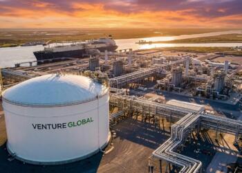 Planta de GNL de Venture Global de noche con tanques de almacenamiento y un carguero atracado.