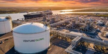 Planta de GNL de Venture Global de noche con tanques de almacenamiento y un carguero atracado.
