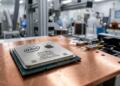 Un procesador de CPU con logotipos de Intel y Apple sobre una placa de cobre en una fábrica