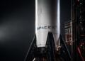 Cohete de SpaceX en primer plano sobre plataforma de lanzamiento industrial.