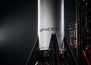 Cohete de SpaceX en primer plano sobre plataforma de lanzamiento industrial.