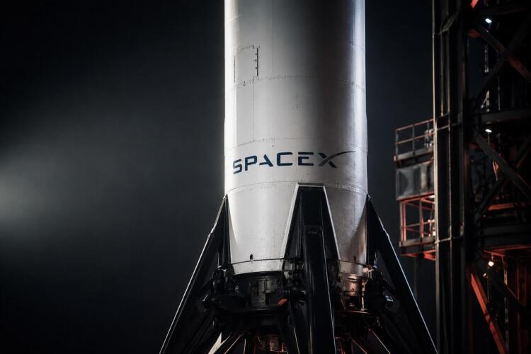 Cohete de SpaceX en primer plano sobre plataforma de lanzamiento industrial.