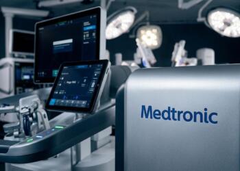 Primer plano de un sistema quirúrgico de Medtronic con múltiples pantallas encendidas en un quirófano.