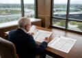 Warren Buffett analiza documentos financieros con logos de Apple y Google en una oficina con vistas a sus sedes.