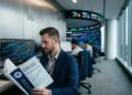 Hombre en oficina de Citadel leyendo un informe de investigación macroeconómica con gráficos.