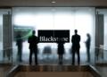 Siluetas de ejecutivos en una oficina de Blackstone frente a un gráfico de rebote financiero.