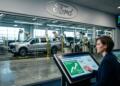 Ejecutiva de Ford interactúa con una pantalla táctil de métricas de producción global.