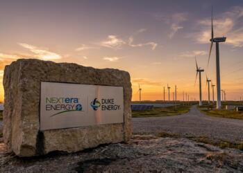 Paisaje al atardecer con aerogeneradores y placas solares en instalaciones de energía.