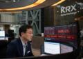 Operador en la Bolsa de Corea frente a una pantalla con alerta de suspensión de mercado.