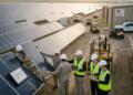 Equipo técnico y analistas revisan la instalación de paneles en una planta de First Solar.
