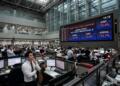 Traders observan pantalla que muestra la suspensión del mercado de valores KOSPI.