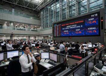 Traders observan pantalla que muestra la suspensión del mercado de valores KOSPI.