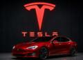 Logotipo de Tesla junto a un vehículo eléctrico de la marca.