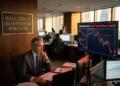 Hombre de traje en el Wall Street Quantitative Risk Desk observa gráficos de mercado en caída.