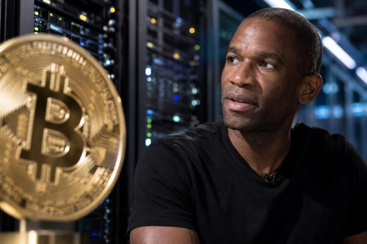Arthur Hayes junto a un símbolo de Bitcoin en primer plano.