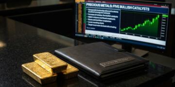 Tres barras de oro y un portafolio de Citadel Securities frente a una pantalla con gráficos.