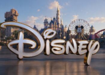 Gran logotipo de Disney con parque temático desenfocado.
