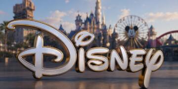 Gran logotipo de Disney con parque temático desenfocado.