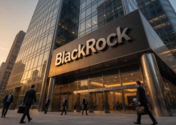 Empleados con traje caminan frente a la entrada del edificio corporativo de BlackRock.