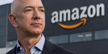 Jeff Bezos frente al logotipo de Amazon en sede corporativa.