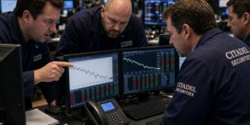 Cuatro operadores de Citadel Securities revisan gráficos de mercado en varias pantallas.