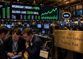 Tres hombres revisan datos frente a una pantalla del NYSE que anuncia un acuerdo de 51B.