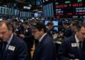 Operadores financieros trabajan por teléfono en el piso de remates de la bolsa de Nueva York.