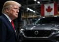 Donald Trump junto a un automóvil canadiense en una fábrica industrial.