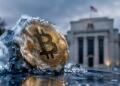 Bitcoin con hielo frente a la Reserva Federal en segundo planos.