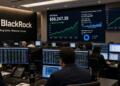 Operadores en la sala de BlackRock observan pantallas con gráficos sobre el precio de Bitcoin.