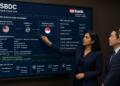 Ejecutiva de U.S. Bank señala detalles de transferencia internacional en una pantalla.
