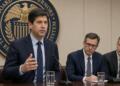 Un funcionario gesticula frente a un micrófono bajo el sello de la Reserva Federal.
