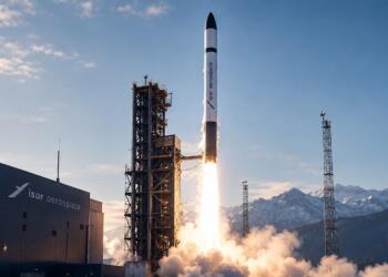 Cohete de Isar Aerospace despega junto a una torre de lanzamiento.