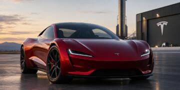 Tesla Roadster rojo frente a un hangar de SpaceX y un cohete.