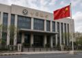Edificio del Banco de China con bandera china izada al frente.