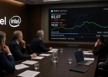 Profesionales se reúnen en una sala frente a una pantalla con datos financieros de Intel.