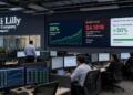 Empleados trabajan frente a pantallas con datos financieros y crecimiento de Eli Lilly.