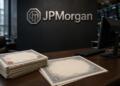 Escritorio con certificados de bonos y logo de JPMorgan al fondo.