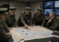 Un grupo de oficiales militares examina un mapa táctico desplegado sobre una mesa.