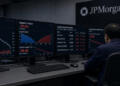 Un operador de JPMorgan observa múltiples pantallas con datos de caídas en acciones de IA.