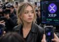 La actriz Sydney Sweeney en medio de la prensa con teléfonos y pantallas mostrando XRP.