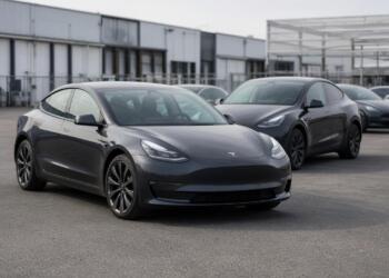Varios vehículos Tesla estacionados en un patio industrial de entregas